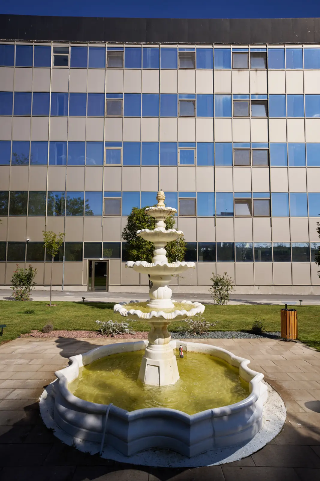 Fântână decorativă albă cu trei niveluri și apă verde-aurie, amplasată, AsertivO Otopeni